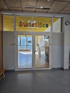 Druk ścienny wykonany przez firmę ŚCIANA WOW w szkole w Warszawie. Druk ścienny wykonany na szkle, na drzwiach. Oznaczenie pomieszczenia. Świetlica w szkole.